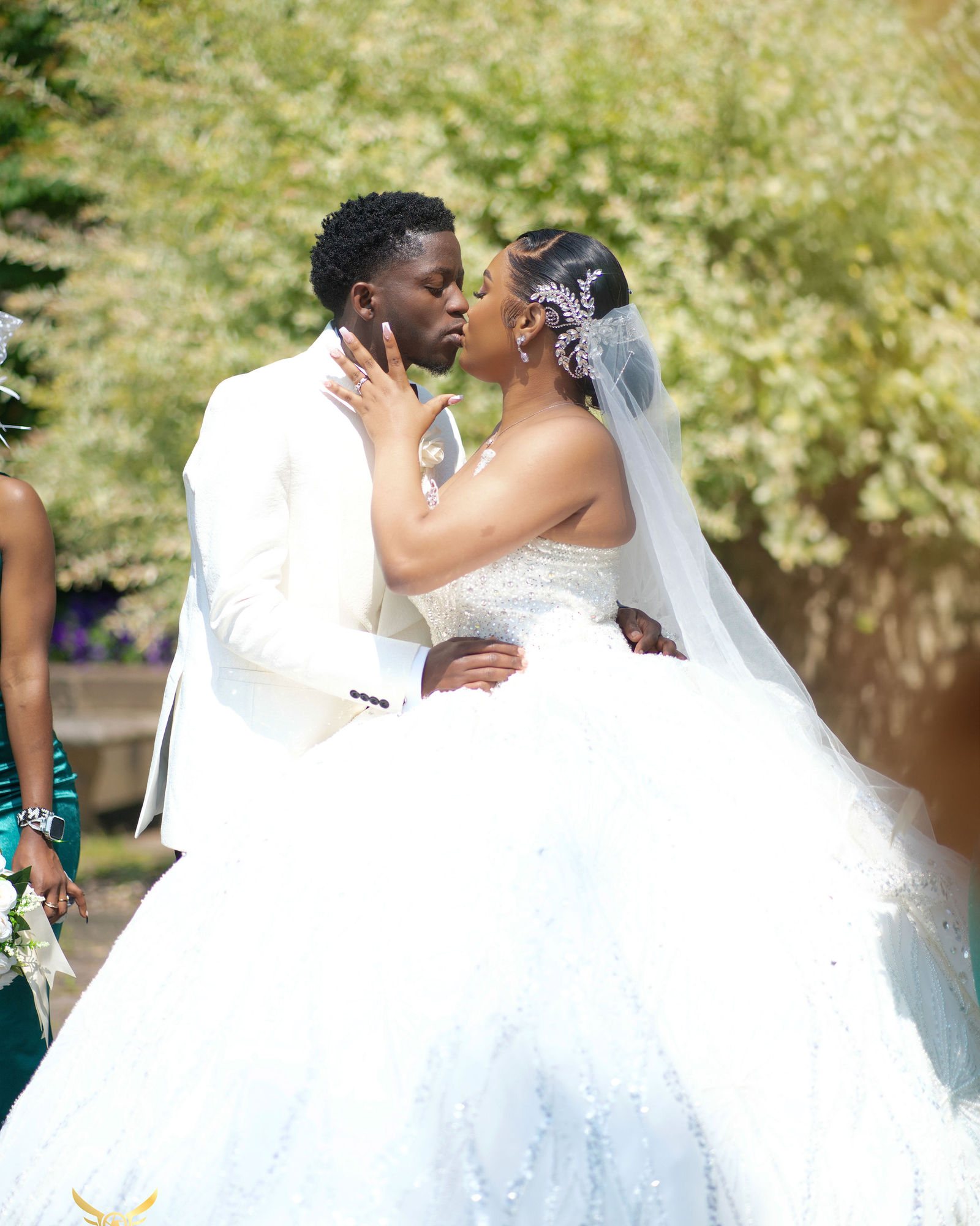 Couple kissing beneath a flowing veil in a garden