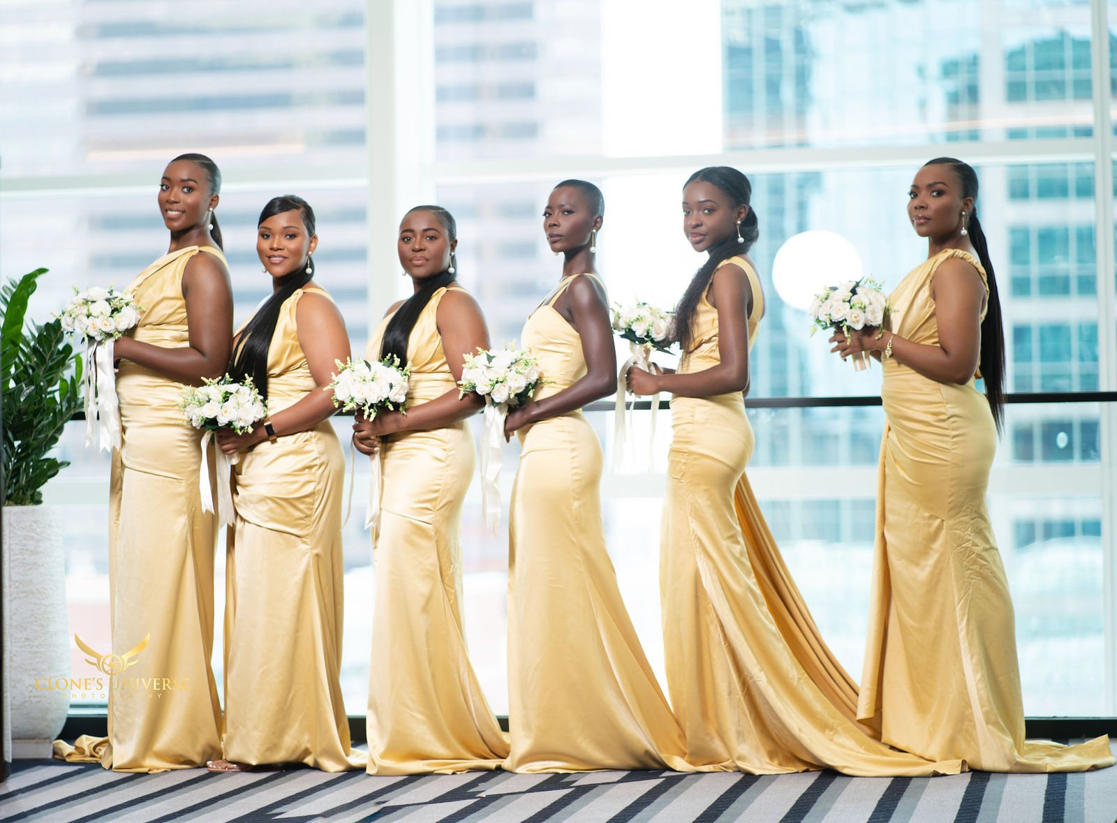 Bridesmaids in gold gowns against a glass skyline